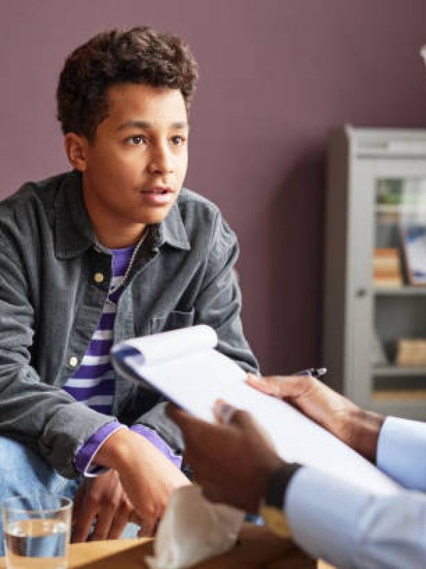 Excited teenage boy sharing his thoughts with adolescent psychologist
